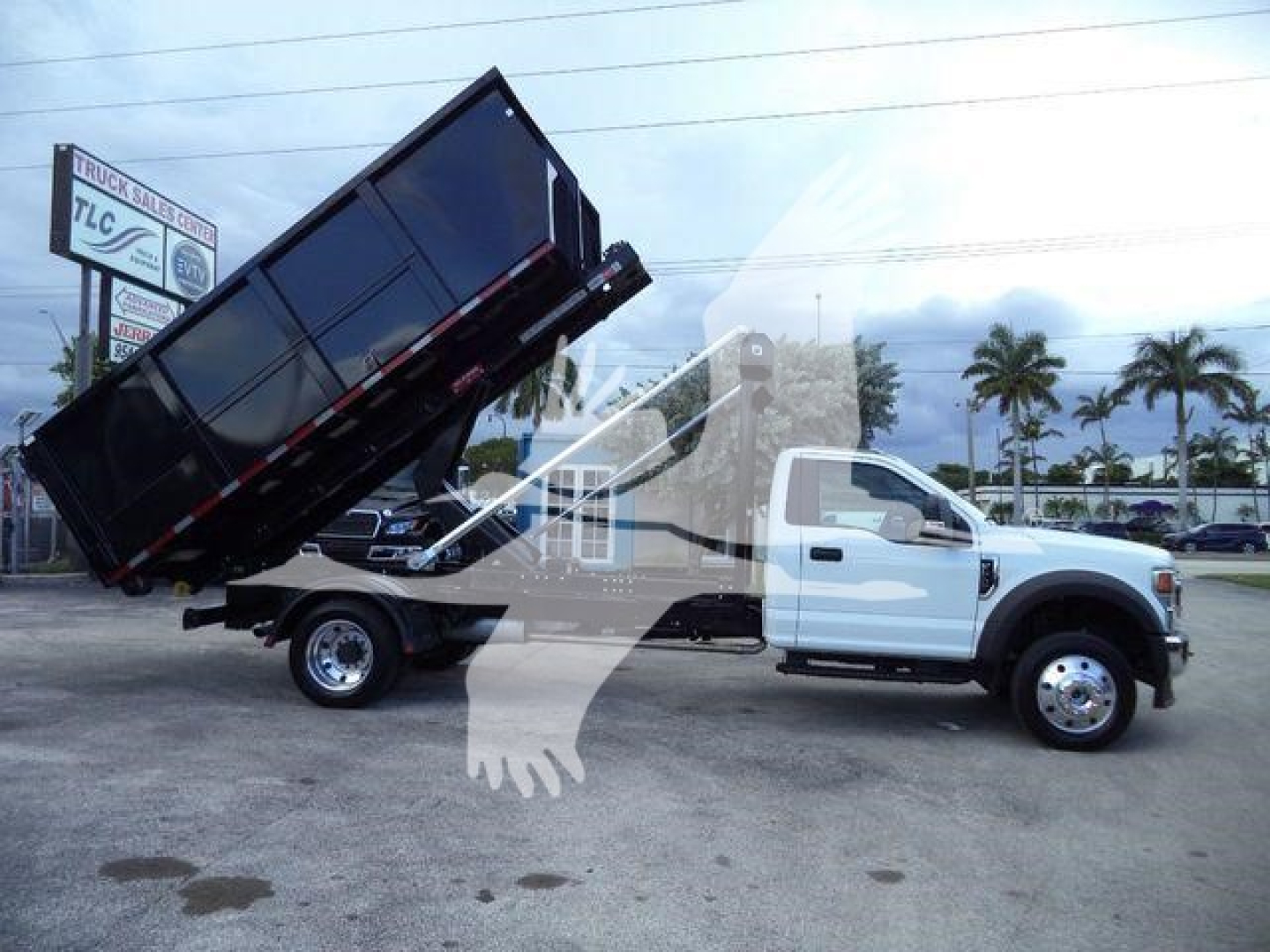 2022 Ford F550 dump truck in a rollover position showing a raised black dump bed and white cab.