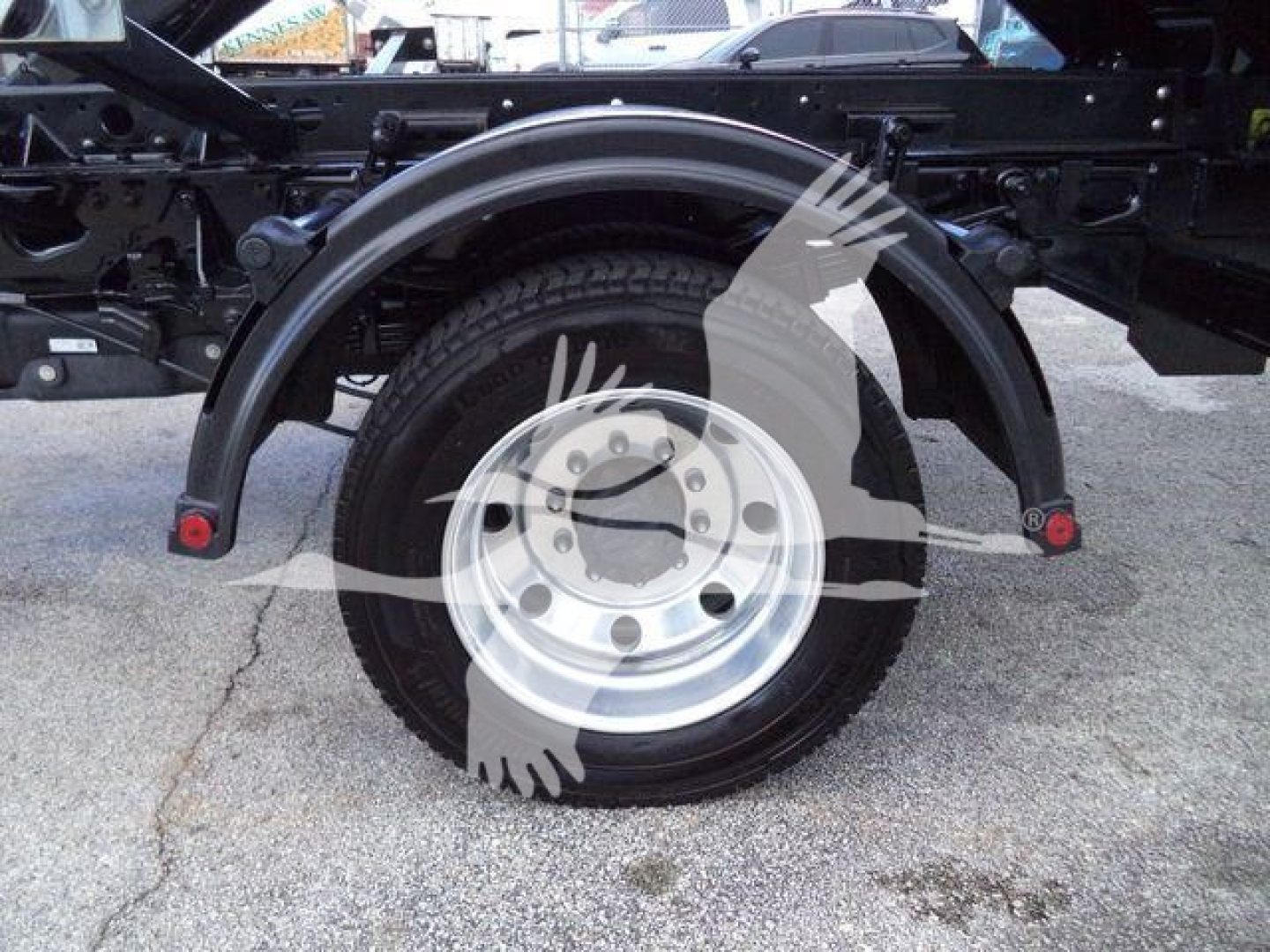 Ford F550 roll-off truck rear view showing single rear wheel with fender arch and framework.