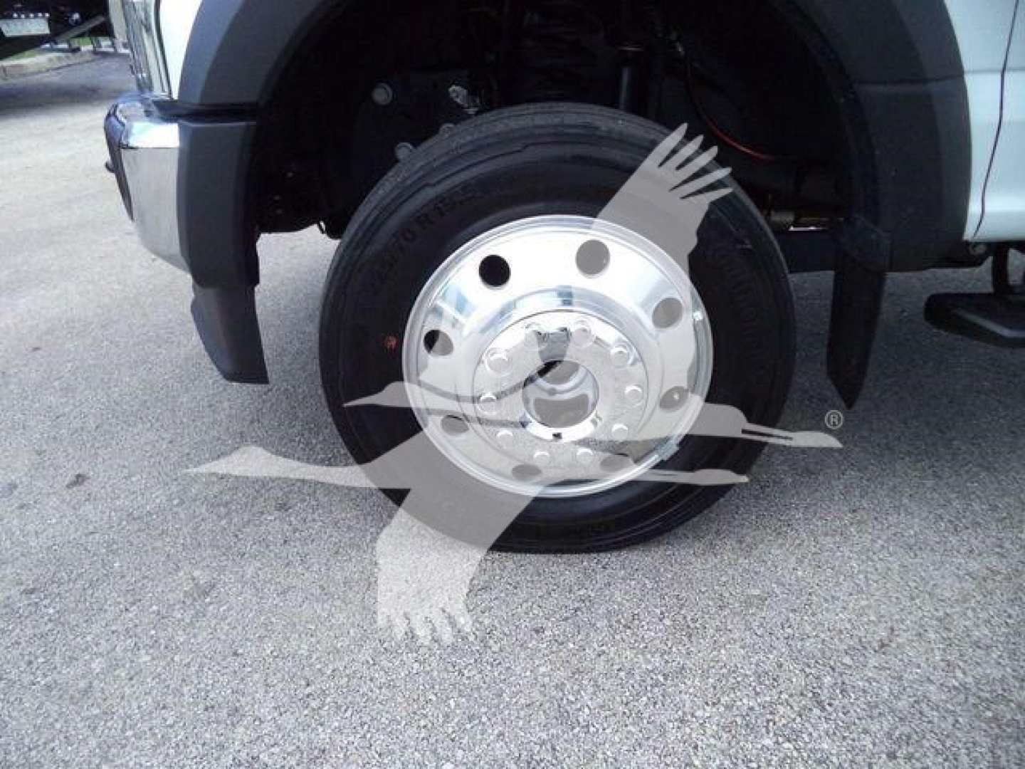Ford F-550 front wheel and fender with wheel hub and tire visible; no legible text on the wheel itself aside from generic wheel details.