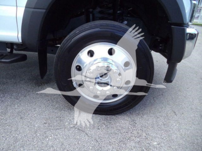 Wheel and front fender of a 2022 Ford F550 rolloff truck showing front wheel with steel rim and hub, partial bumper and tire tread.