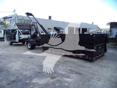 Ford F550 roll-off truck with black enclosed container and crane, side view showing stock number and factory body.