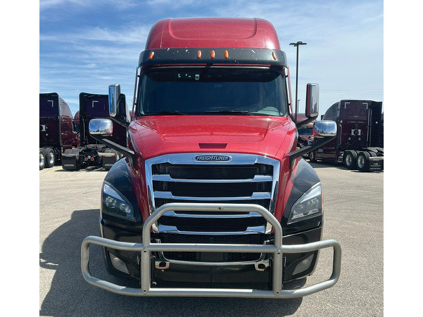 Freightliner Cascadia126 tractor-trailer front view showing chrome grille, bumper guard, and red cab.