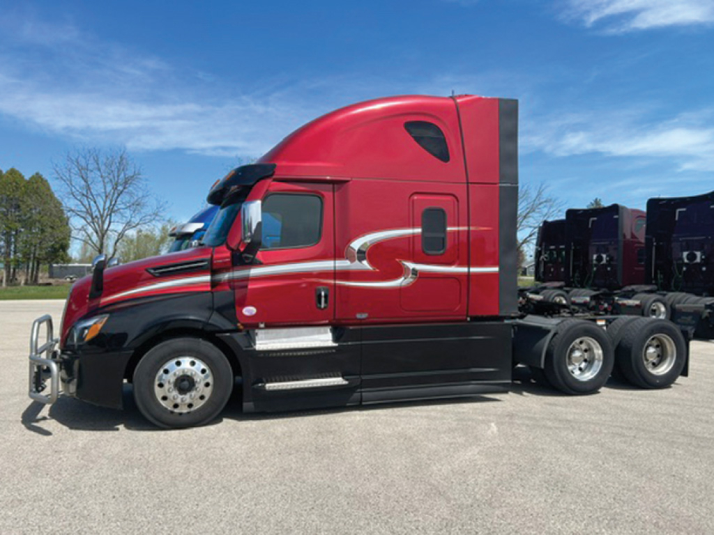 Side view of a red Freightliner Cascadia126 semi-truck tractor with sleeper cab, black lower panels, and chrome accents.