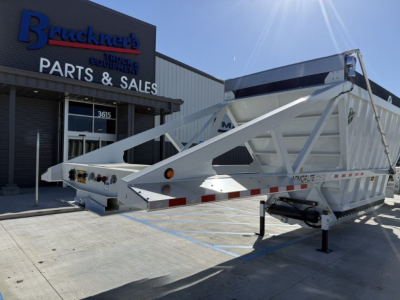 Armor Lite SBD40 Spring skeleton trailer showing steel frame and gooseneck hitch in front of a parts and sales building.