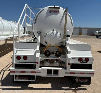 Dragon 130BBL vacuum trailer rear view showing circular tank with hatches, safety rails, taillights, hoses, and labels.