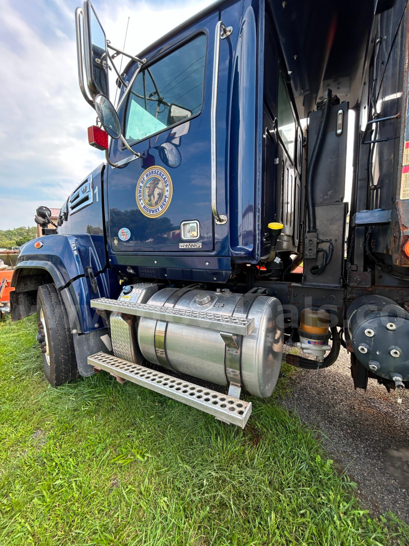 Truck side view showing fuel tanks and step bar of a blue 2018 Western Star 4700 cab with plow duty.