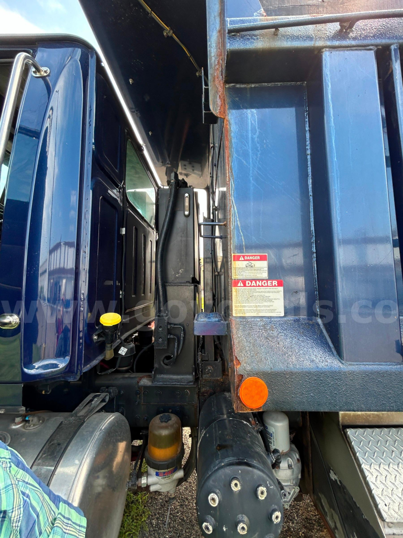 Western Star 4700 truck side view showing cab and plow equipment with warning labels and hydraulic components.