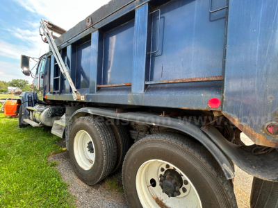 Western Star 4700 dump truck side view showing dual rear wheels and blue dump body.