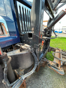Western Star 4700 truck front-left side with hydraulic lines and plow mount; close-up of chassis and hydraulic cylinders.
