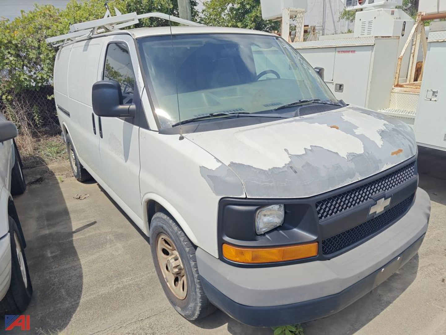 Chevrolet Express 1500 cargo van front-left view showing peeling paint on hood, black grille with Chevy bowtie, amber turn signals, and side mirror.