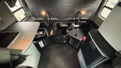 Kenworth T680 cab interior showing driver and passenger area, control panels, seats, and dash area with overhead instruments.