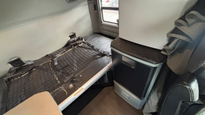 Kenworth T680 interior sleeper area with cargo area showing storage shelf and netting.