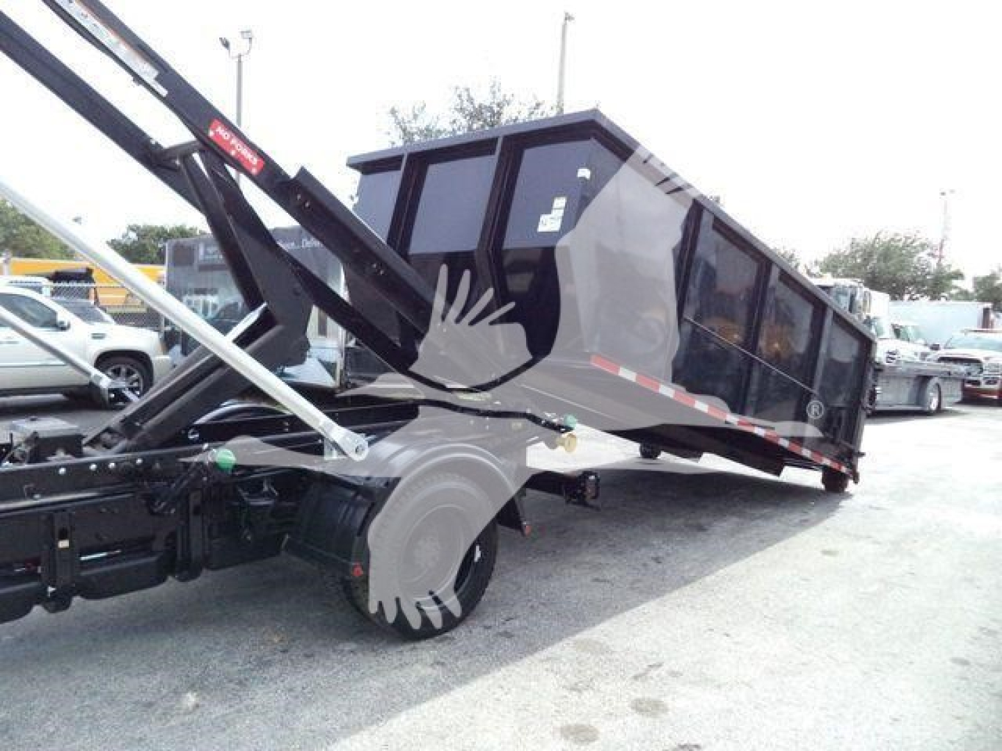 Chevrolet Silverado 6500HD rolloff truck in service with lifted bed and side-view showing cargo container and hydraulic arms.