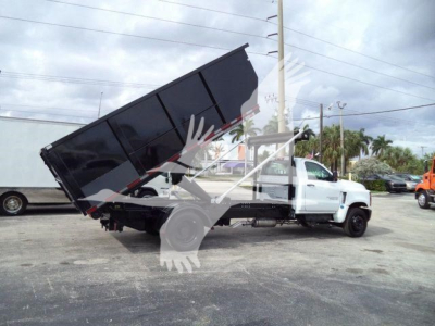 Chevrolet Silverado 6500HD dump truck in a tilted bed configuration showing a dump bed raised on a white cab chassis.