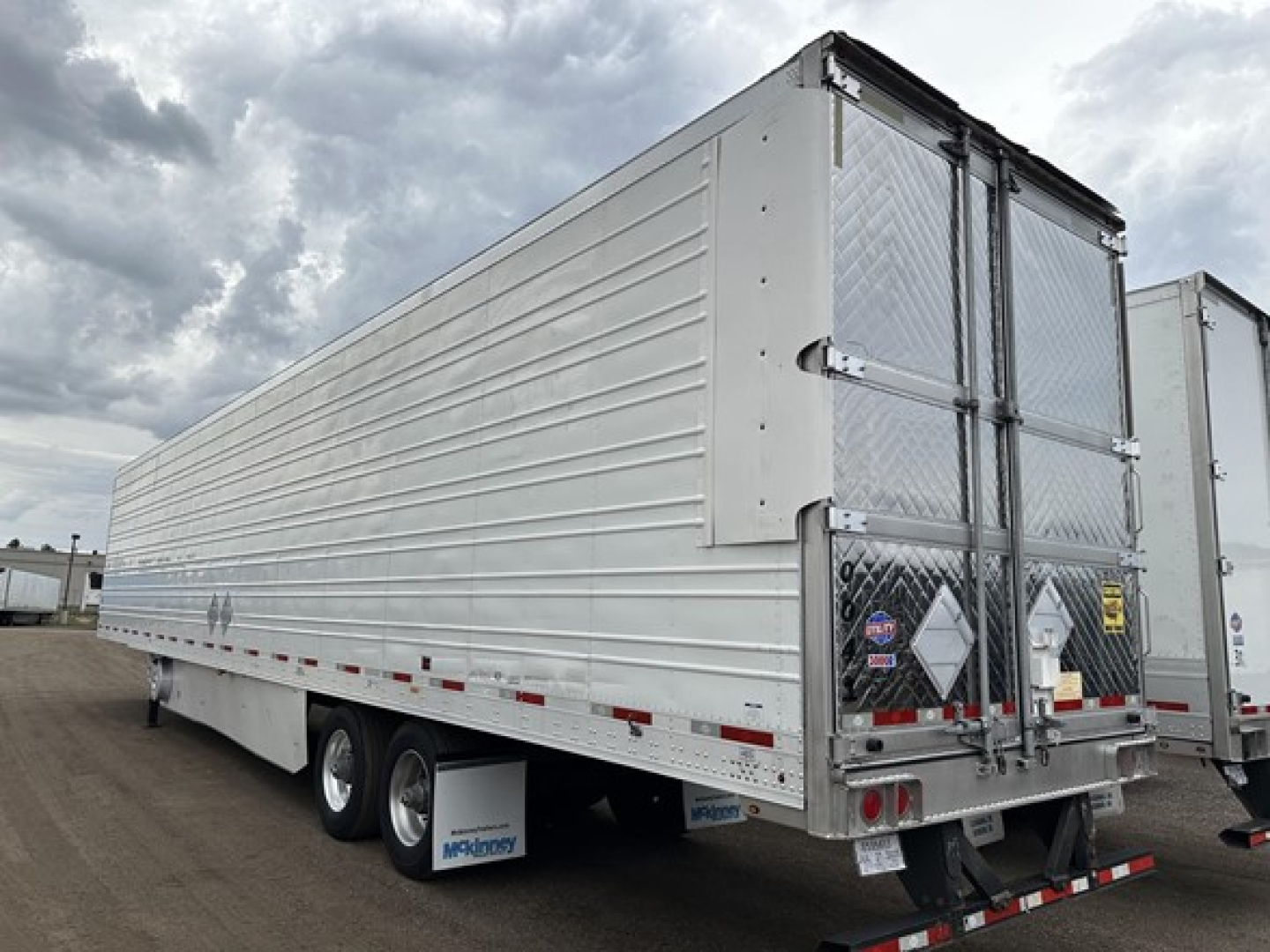 Trailer side view of a 2020 Utility 3000R reefer trailer showing aluminum side panels and dual rear doors with diamond plate on the bottom corner guards.