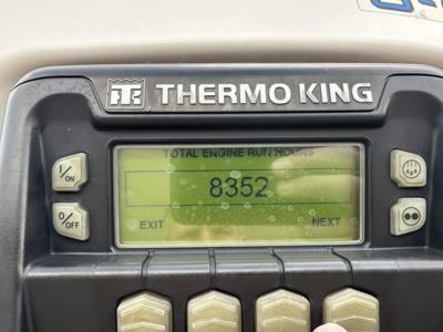 Thermo King unit with digital display showing total engine hours 8352 on reefer trailer. Thermo King logo above screen and control buttons on sides.