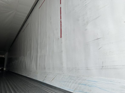 Trailer interior wall and floor of a 2020 Utility 3000R refrigerated trailer showing smooth white wall with faint scuff marks and linear equipment markings.