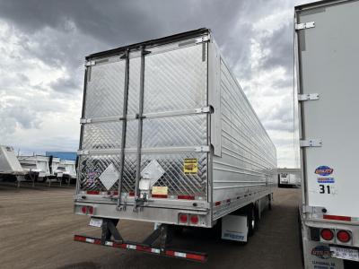 Rear view of a used 2020 Utility 3000R trailer with diamond plate aluminum doors, dual rear doors, and taillights. Visible stickers and warning labels on doors, bumper with lights.