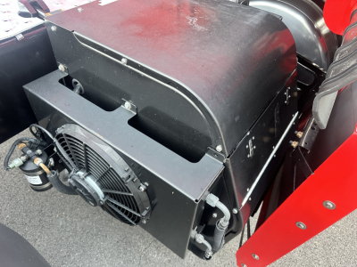 Newer Freightliner Cascadia 126 engine bay area showing radiator, cooling fan, and black metal shroud. Compact coolant/air intake components visible.