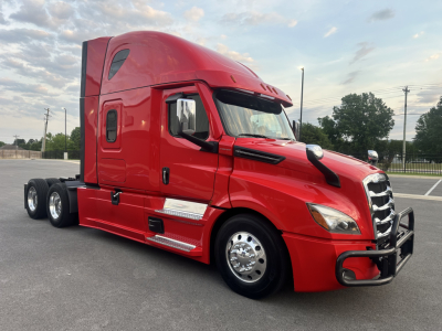 Freightliner Cascadia 126 tractor-trailer side view showing red cab and chrome wheels.