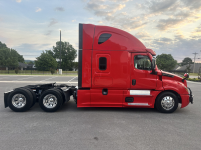 Truck side view showing a red 2022 Freightliner Cascadia 126 tractor with a sleeper cab, two rear axles, chrome wheels, and black chassis.