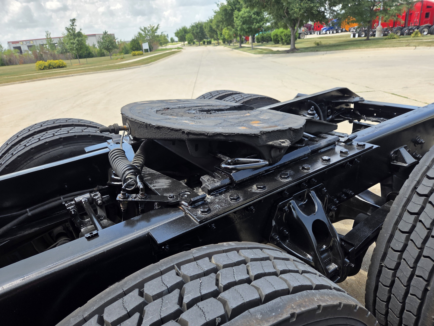 Kenworth T680 chassis view showing rear wheel region and fifth wheel mounting with visible frame, springs, and suspension.