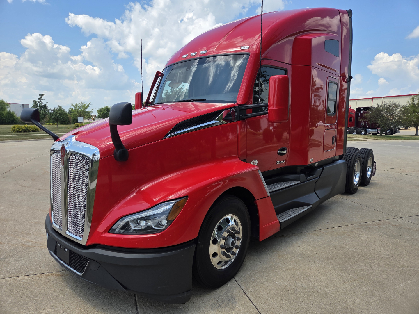 Kenworth T680 tractor unit in red, side view showing front grille, headlights, mirrors, and sleeper cab.