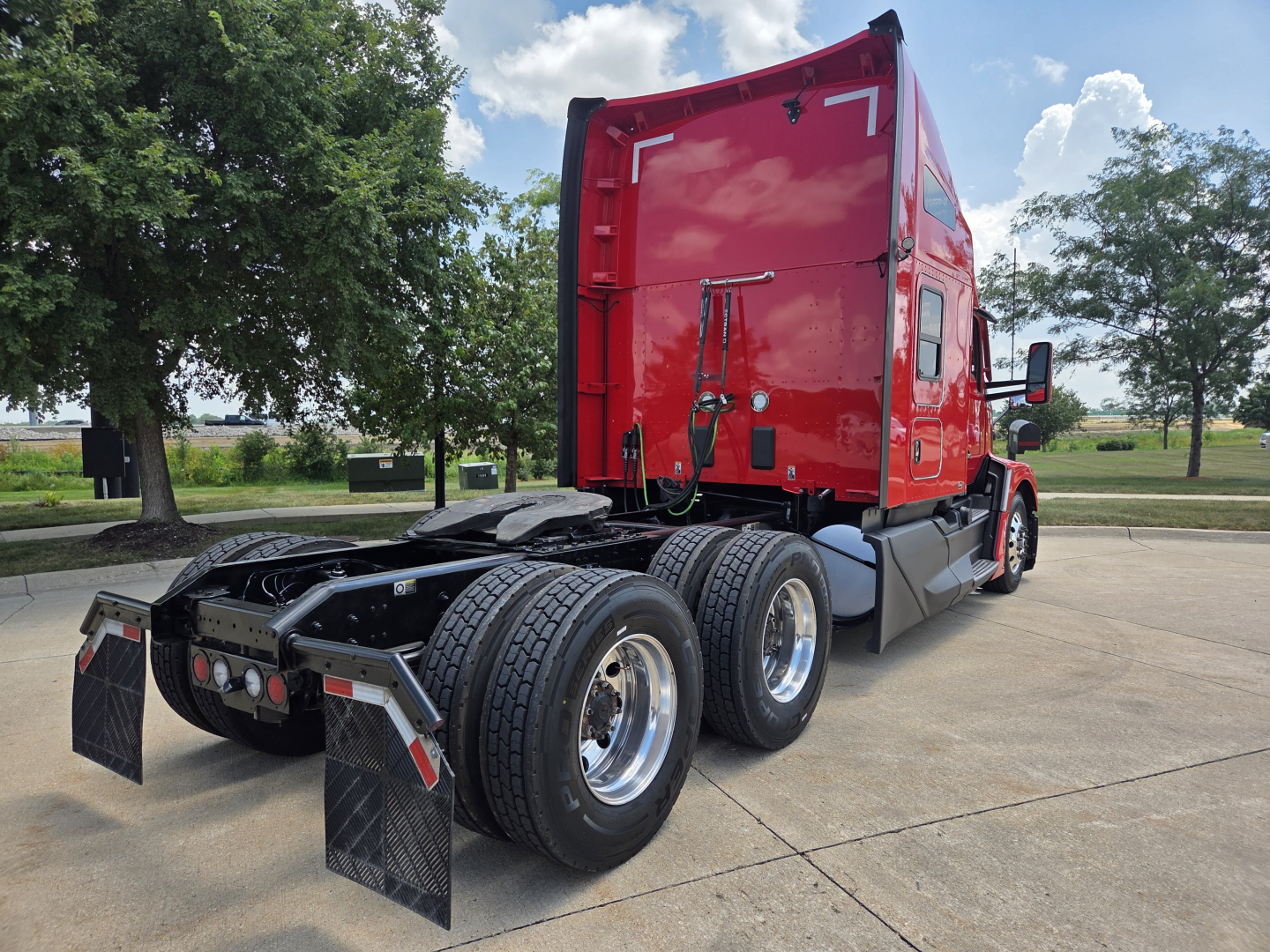 Kenworth T680 semi truck rear view showing sleeper cab and dual rear axles with mud flaps