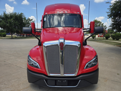 Kenworth T680 truck front view showing chrome grille and red cab with black bumper and side mirrors.