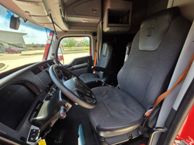 Kenworth T680 interior cab with driver seat and steering wheel, dashboard, and doorway visible