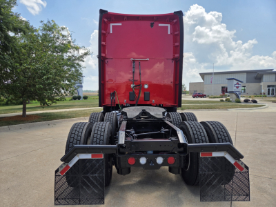 Kenworth T680 rear tractor view showing fifth wheel, dual rear axles, and mud flaps with stock photos. Red sleeper cab with rear door open.