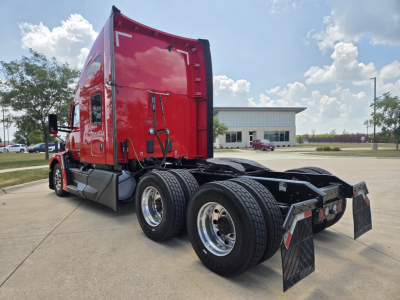 Kenworth T680 highway tractor chassis and cab in red, rear view showing dual rear axles and fifth wheel area.