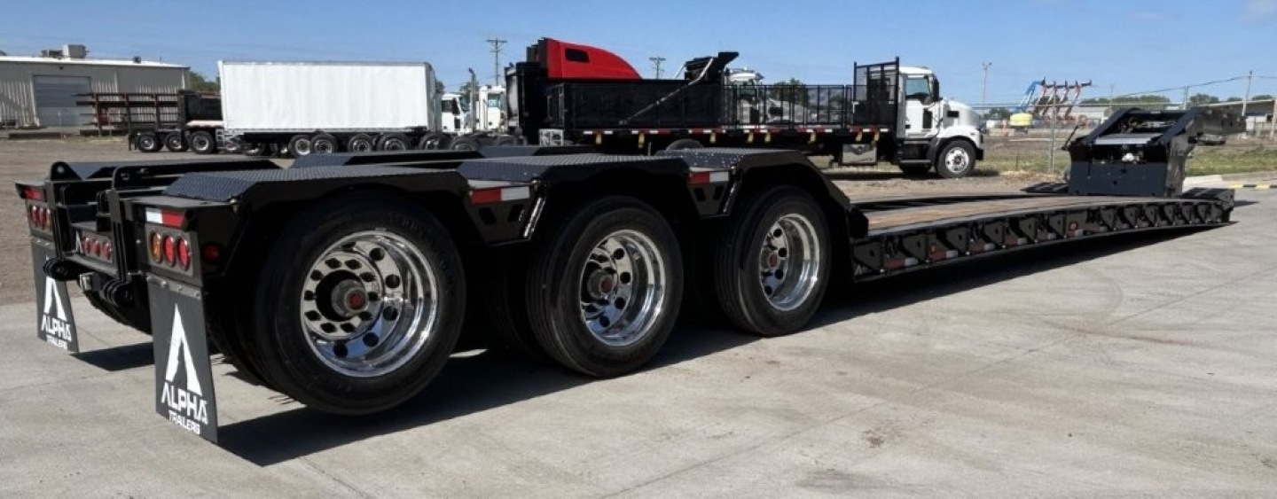 Trailer: A110HDG-SF-18, LDH lowboy trailer with 26' deck, three-axle configuration, black with chrome wheels, side rails, and rear tail lighting.