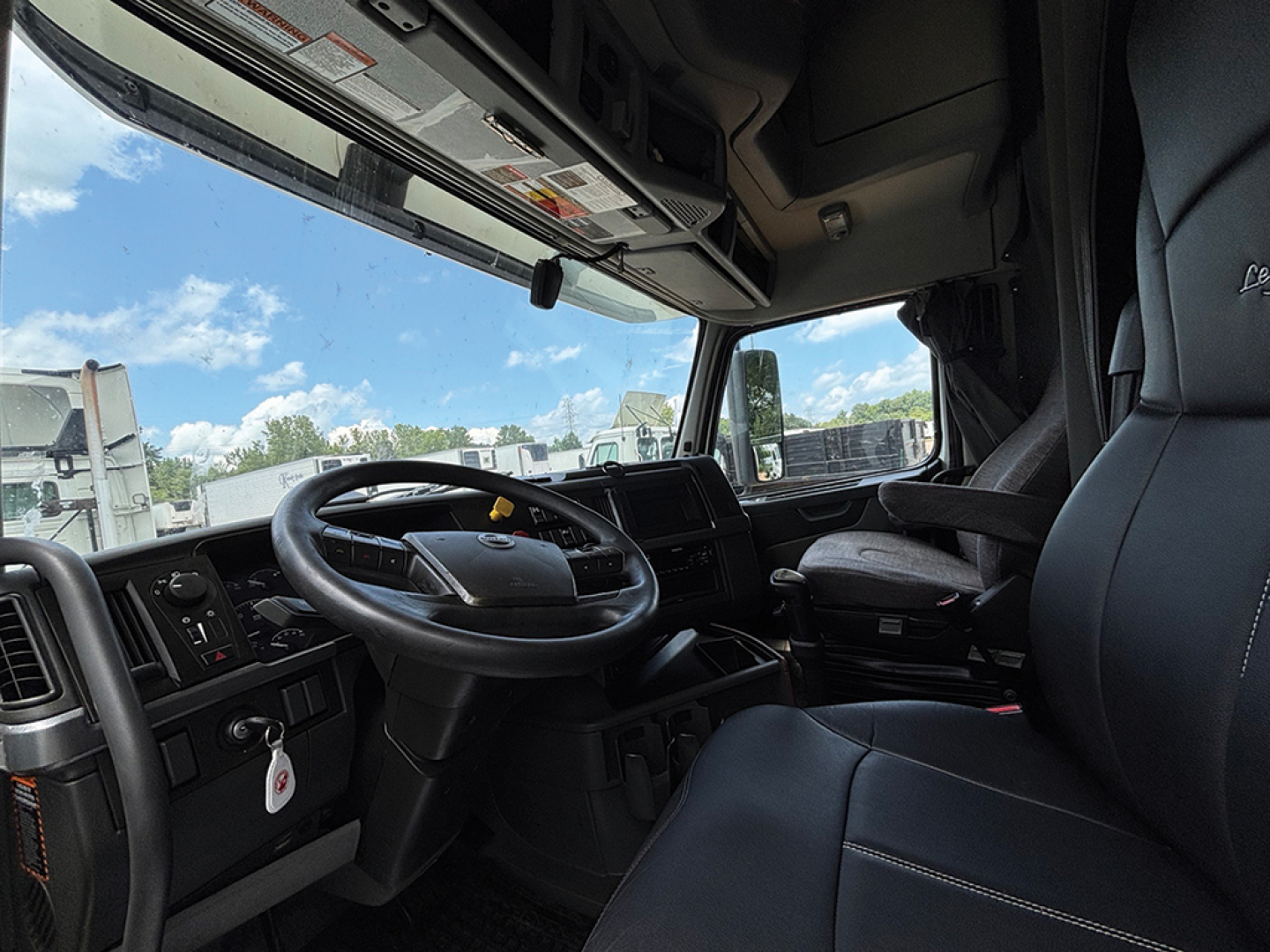 Volvo VNL 760 truck cabin interior showing steering wheel and driver seat with front dashboard and windshield.