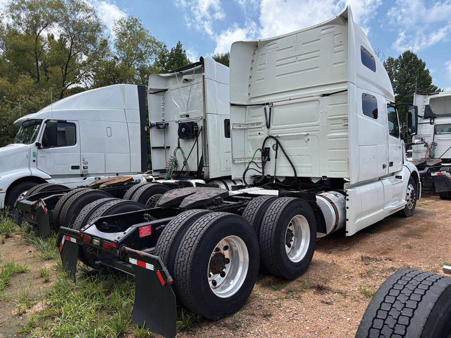 Side view of a 2019 Volvo VNL 760 tractor with sleeper cab, showing rear tandem axles and white exterior.
