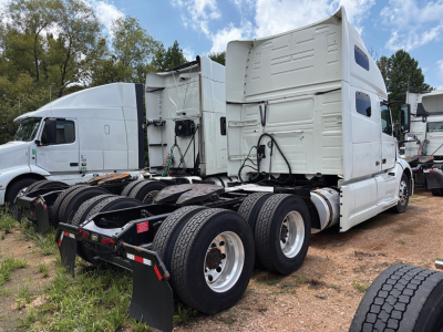 Side view of a 2019 Volvo VNL 760 tractor with sleeper cab, showing rear tandem axles and white exterior.