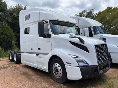 Tractor-trailer truck cab in white showing Volvo VNL 760 design with chrome grille, large windshield, sleeper cab, and dual rear axles.