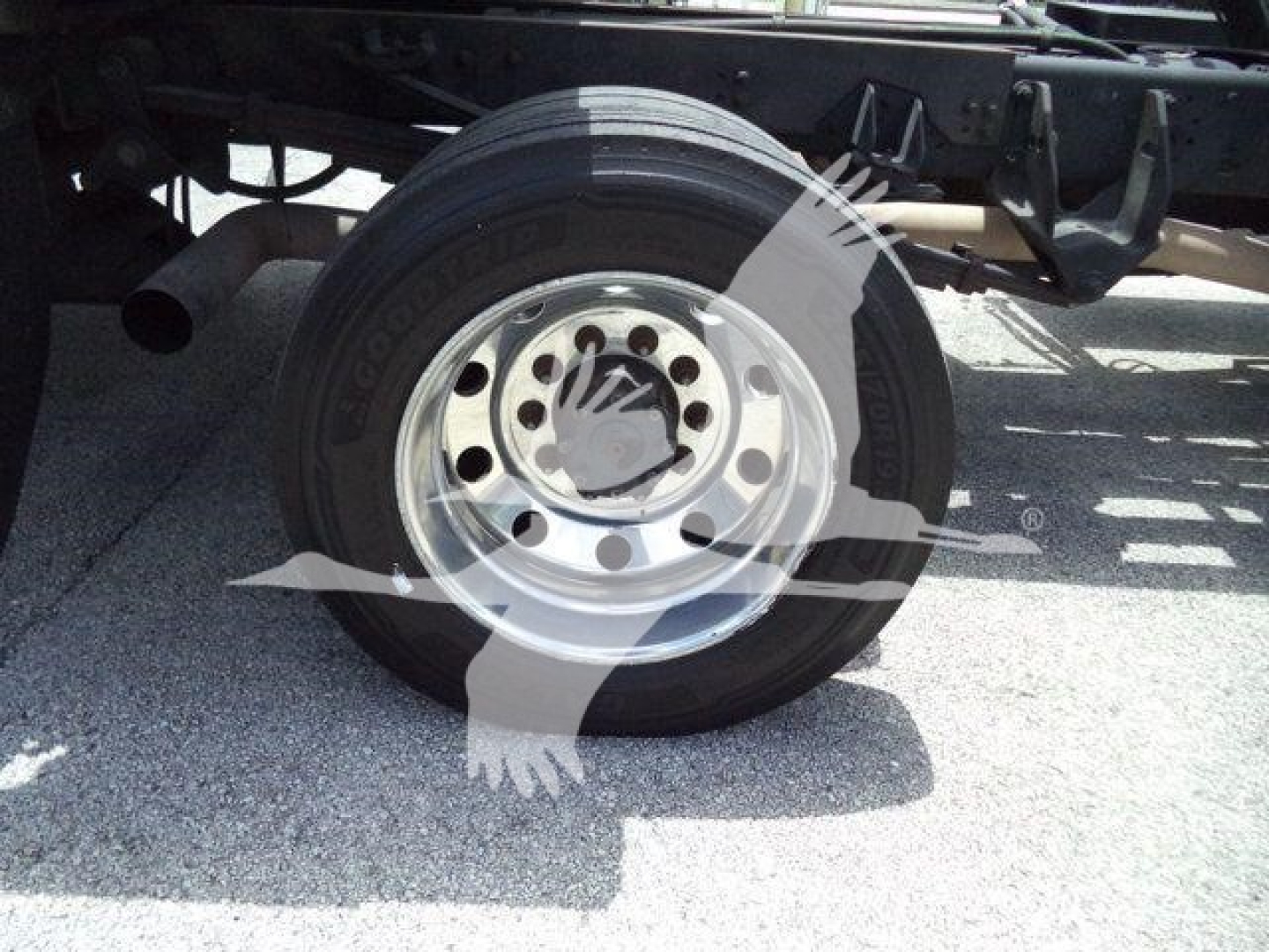 Truck rear wheel and suspension components showing a Goodyear tire mounted on a steel wheel; frame and leaf spring visible.