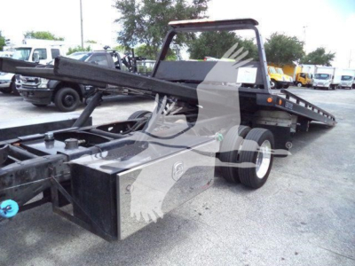 Ram flatbed rollback truck chassis showing front winch and hitch with toolbox, side rails, and wheel; no legible text visible.