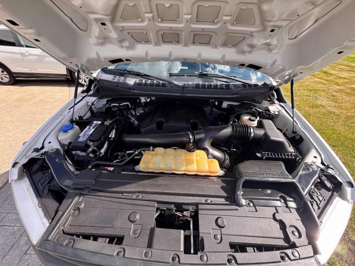 Ford F-150 2018 engine bay with hood open showing coolant reservoir, air intake, and engine components.