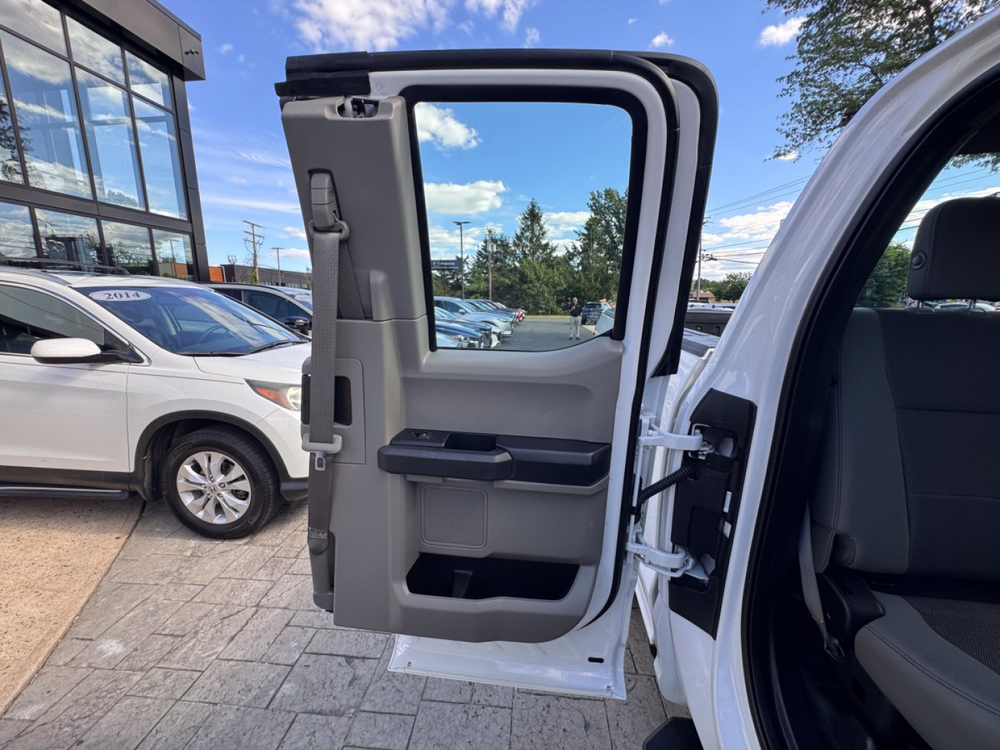 Truck door interior view on a 2018 Ford F-150 showing open rear passenger door with beige trim and storage pockets.