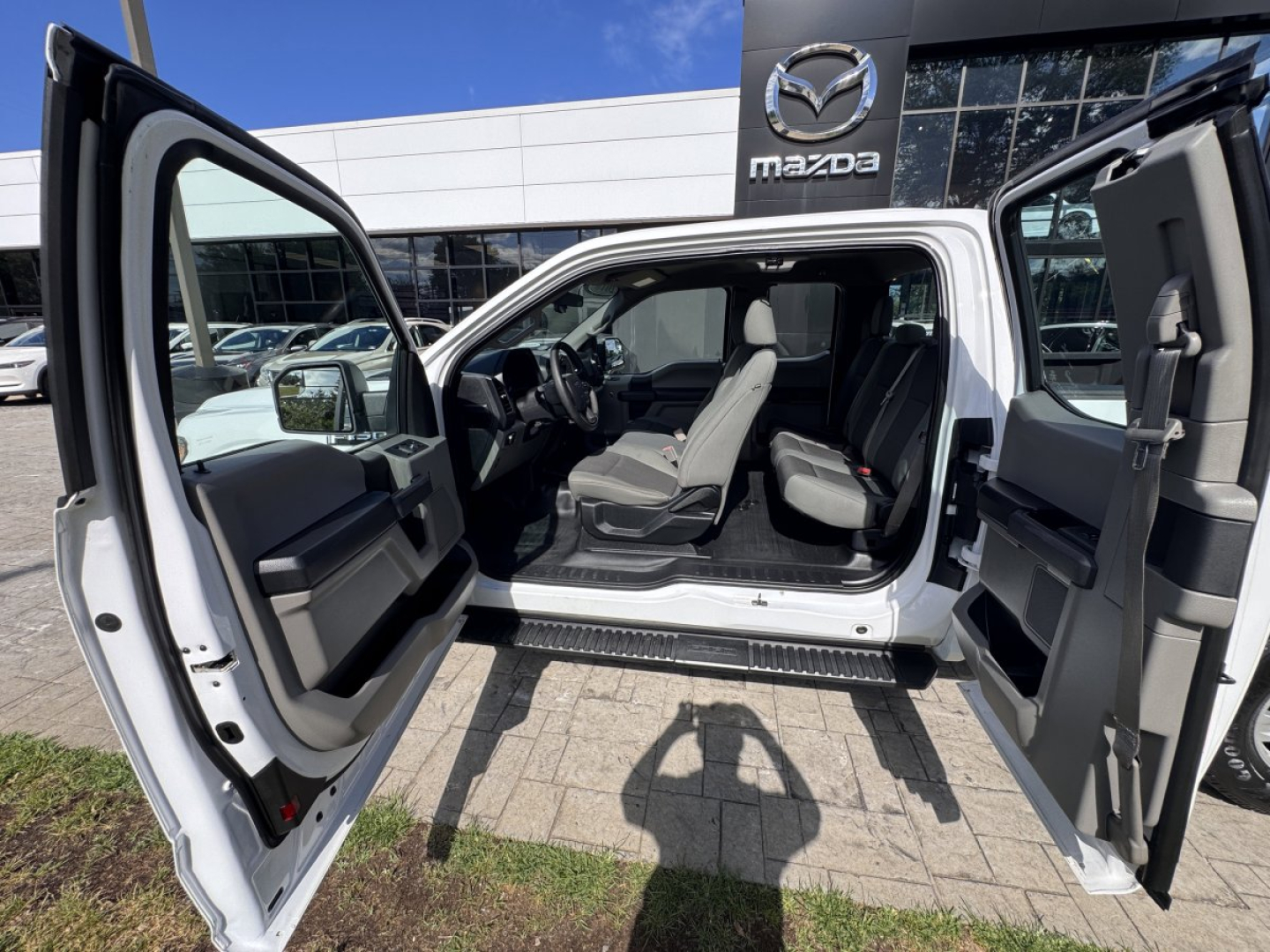 Ford F-150 crew cab interior with all doors open, showing front and rear seats and dashboard.