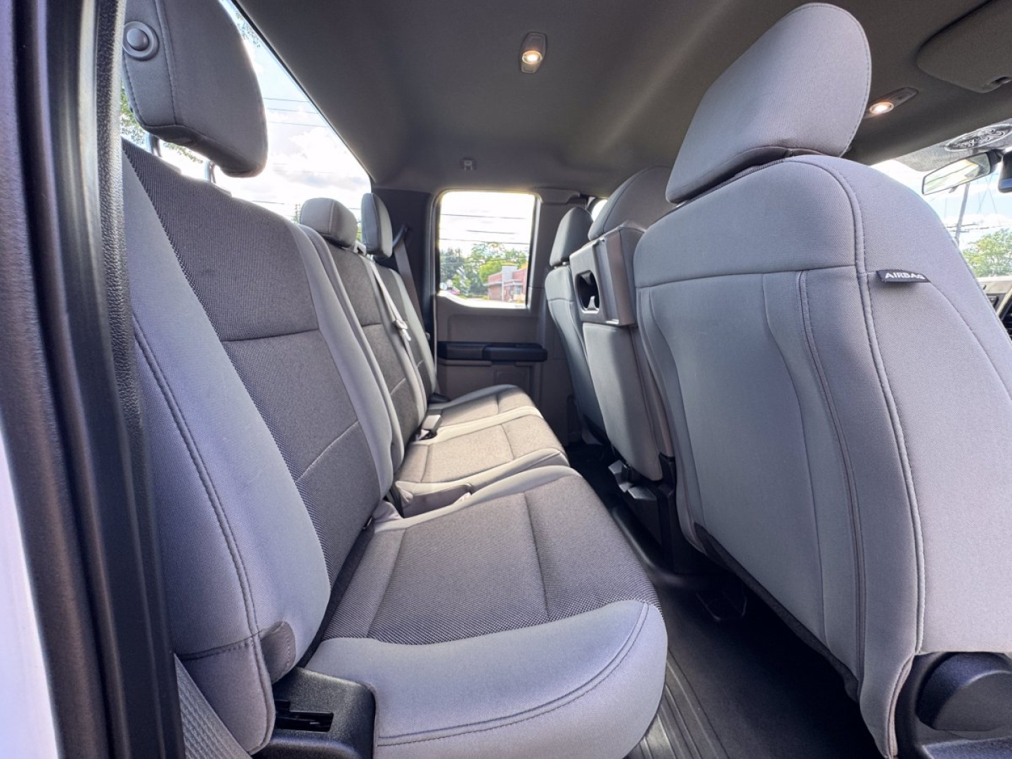Ford F-150 interior rear seat view showing gray cloth upholstery in cargo area with front seats and headrests.