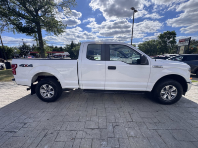 Side view of a white 2018 Ford F-150 pickup truck with extended cab, '4x4' badge on rear quarter, and alloy wheels.