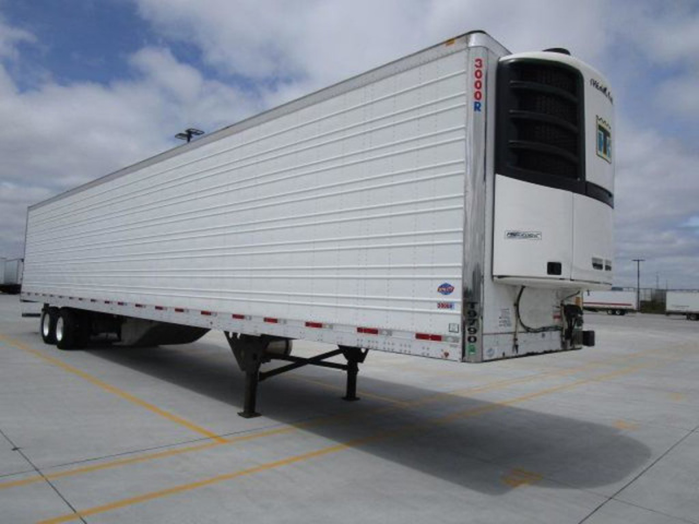 Refrigerated trailer with Thermo King unit showing side and rear doors, two axles, and landing gear in a parking lot.