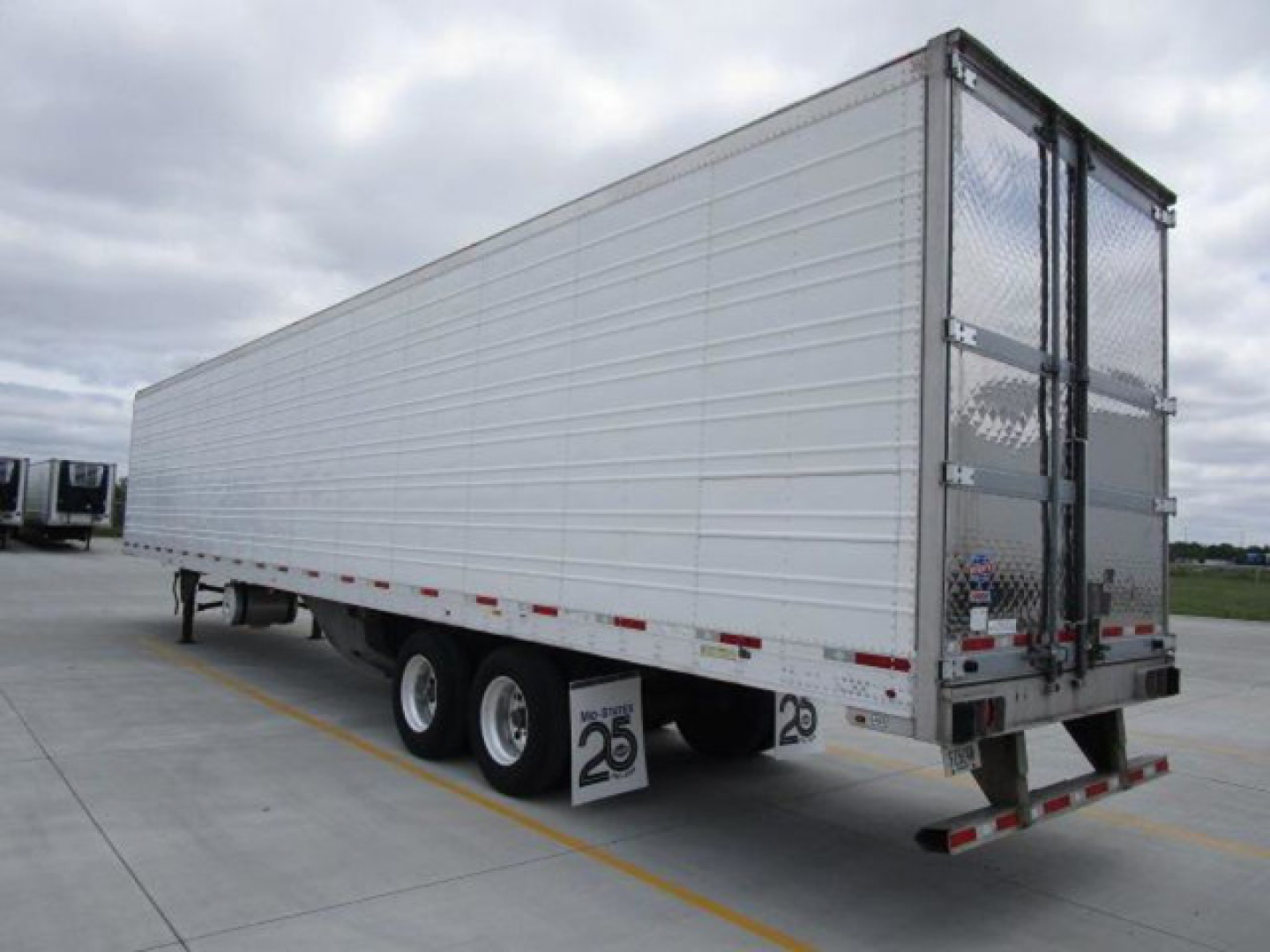 Trailer side view of a 2022 utility refrigerated trailer showing tandem axles and rear doors.