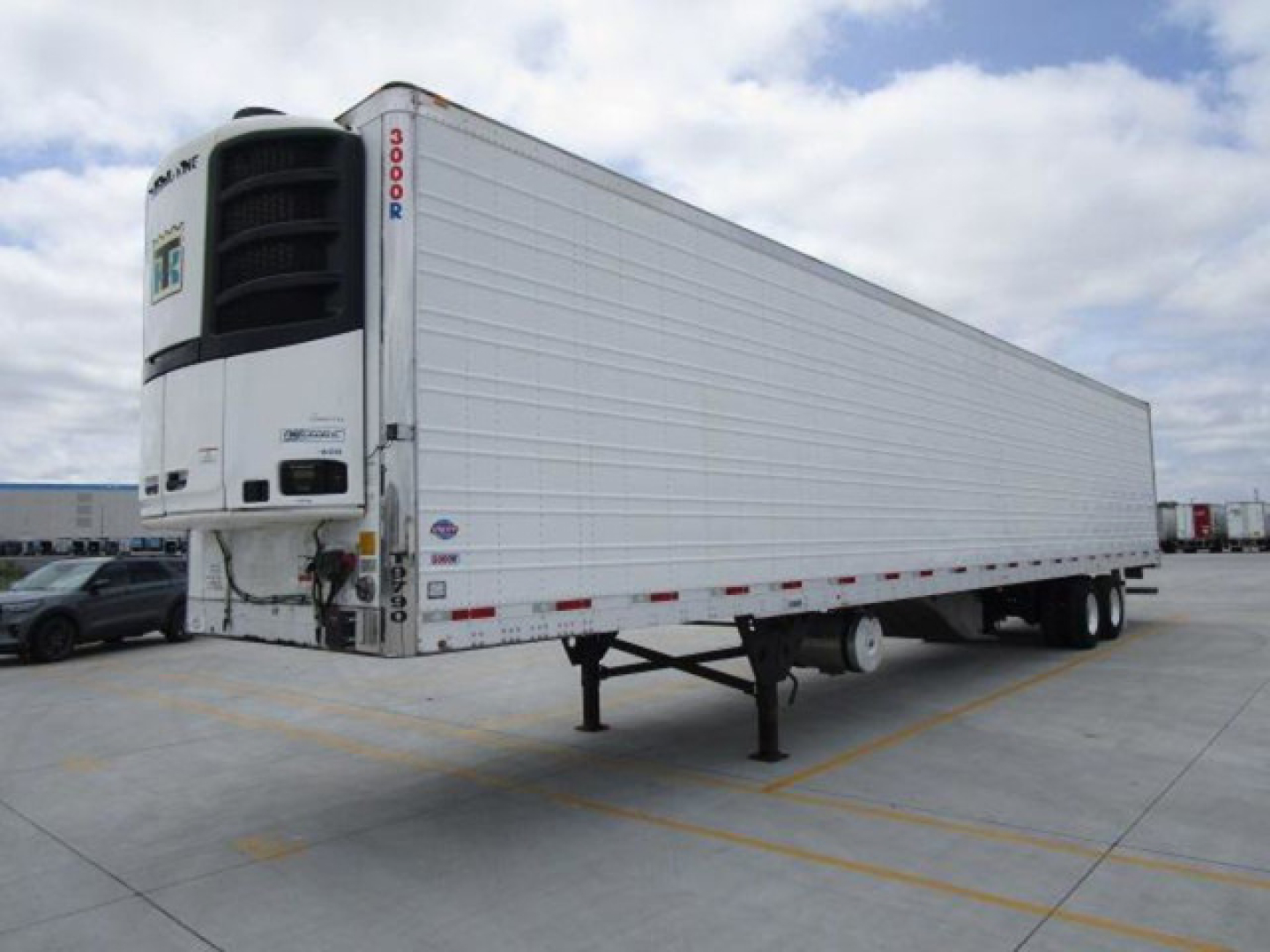 Trailer trailer refrigeration unit at front with white body, side panels, and refrigeration unit mounted at front. Visible text on unit includes 'THERMO KING' style label and numbers '3000R' on vertical edge; trailer has no other legible la