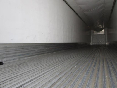 Trailer interior showing corrugated aluminum floor with ribbed texture, sidewall, and rear cargo door opening, for a refrigerated trailer.