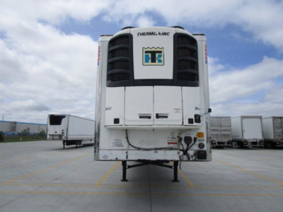 Reefer trailer rear view showing Thermo King unit and raised landing gear in a truck yard.