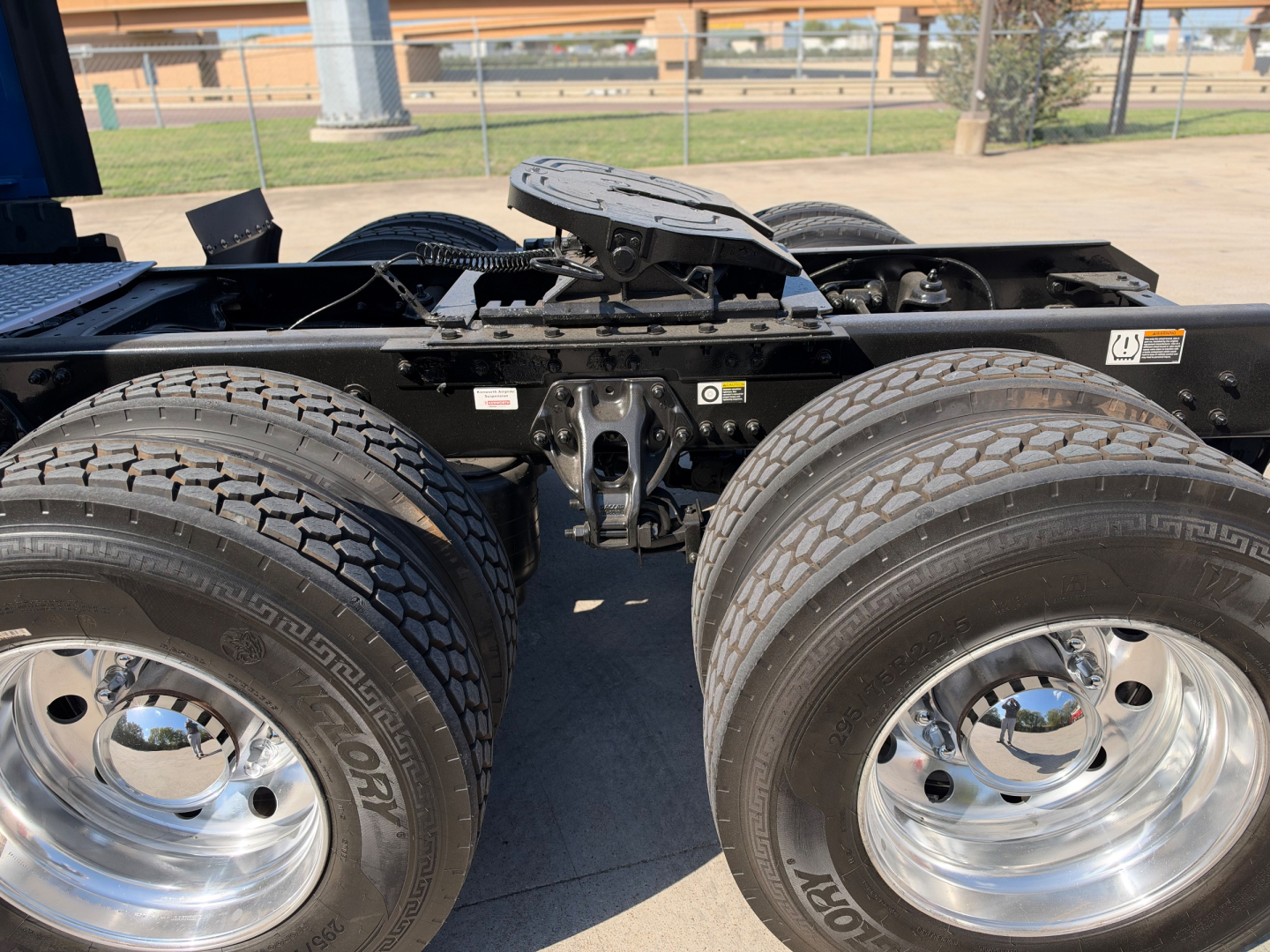 Kenworth T680 chassis with dual rear axles and chrome wheels showing hitch area and frame. Visible tires and wheel rims.